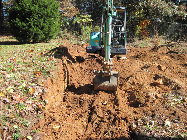Excavating into hill for retaining wall