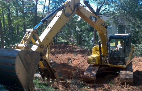 Excavator digging stump removal grinding